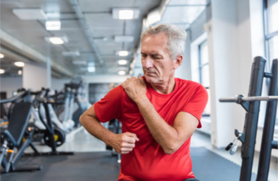 man holding his frozen shoulder at the gym